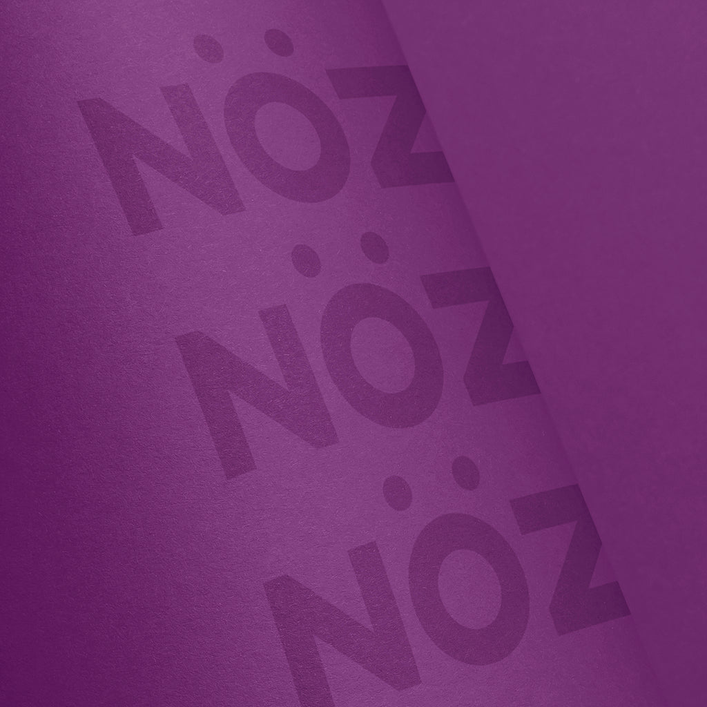 Close up of Nöz’s logo, on its cruelty free sunscreen stick, in the color neon purple.