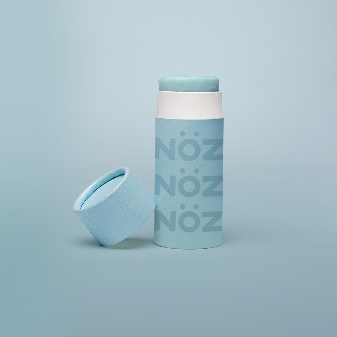 Nöz’s natural zinc and vegan sunscreen stick in neon blue, with its cap off.