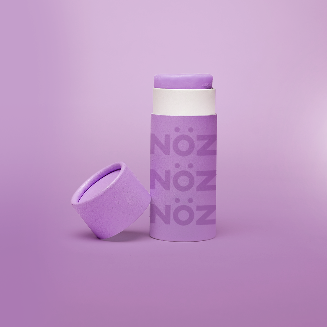 Nöz’s natural zinc and vegan sunscreen stick in neon purple, with its cap off.