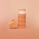 Load image into Gallery viewer, Nöz’s natural zinc and vegan sunscreen stick in neon orange, with its cap off.
