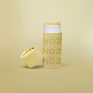 Nöz’s natural zinc and vegan sunscreen stick in neon yellow, with its cap off.