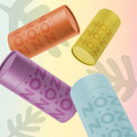 Load image into Gallery viewer, Nöz’s natural zinc and vegan sunscreen sticks levitating on a colorful leaf background in all 4 colors, with their lids on.
