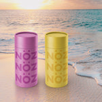 Load image into Gallery viewer, Nöz’s reef safe and vegan sunscreen sticks in the colors neon yellow and purple, on a beach background.
